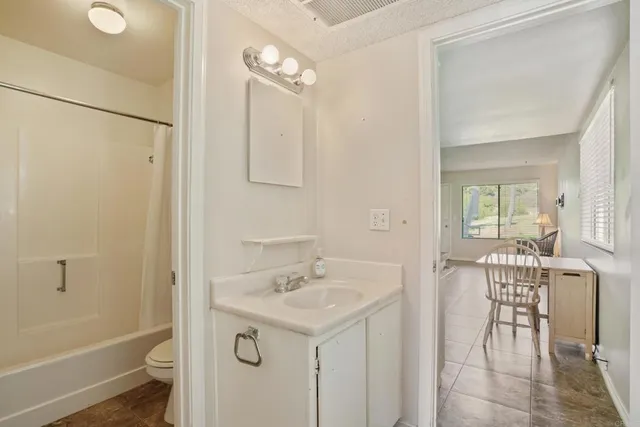 a bathroom with a sink and mirror with toilet