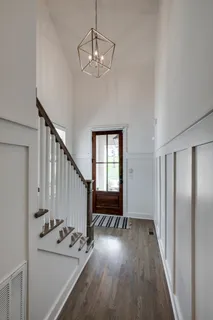 a view of a hallway with wooden floor and staircase