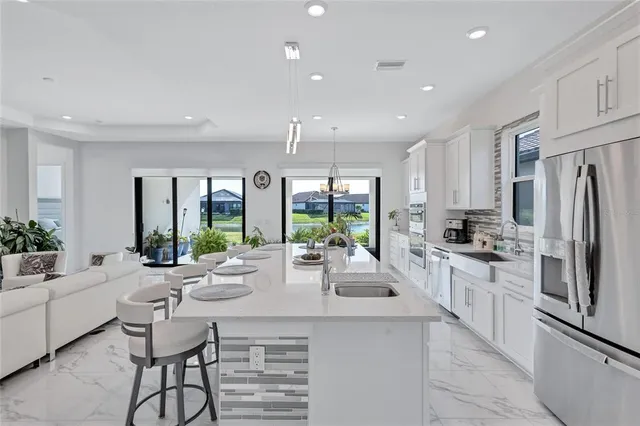 a large kitchen with kitchen island a table and chairs