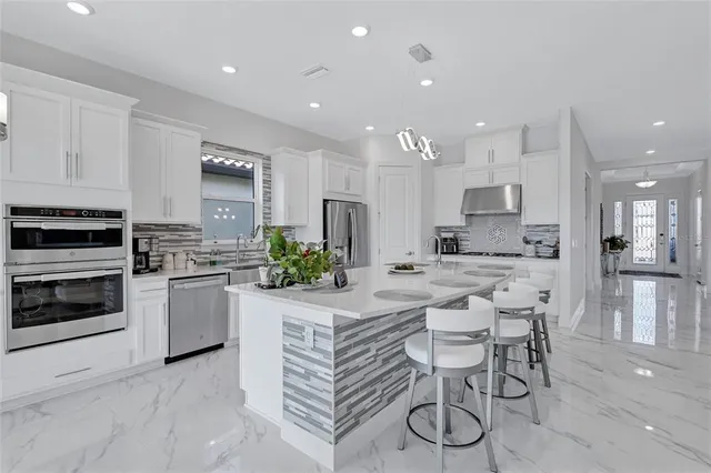 a kitchen with white cabinets and stainless steel appliances