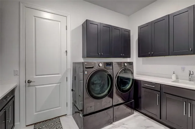 a utility room with sink dryer and washer