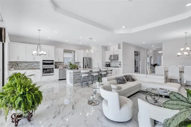 a spacious bedroom with a bed a couch and a flat tv screen on the dresser