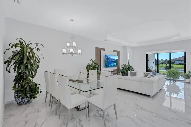 a living room with furniture a large window and a potted plant