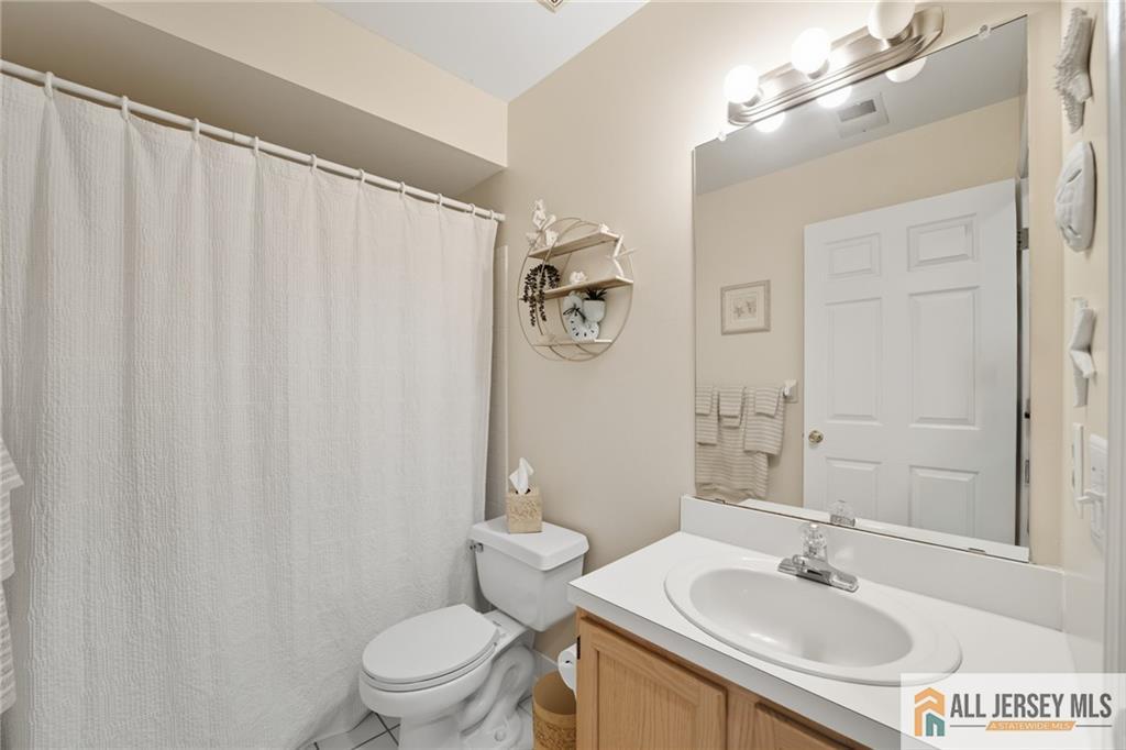 2 Guinevere Road Monroe Township, NJ 08831 - Photo 23 of 40 a bathroom with a sink a toilet a mirror and shower curtain