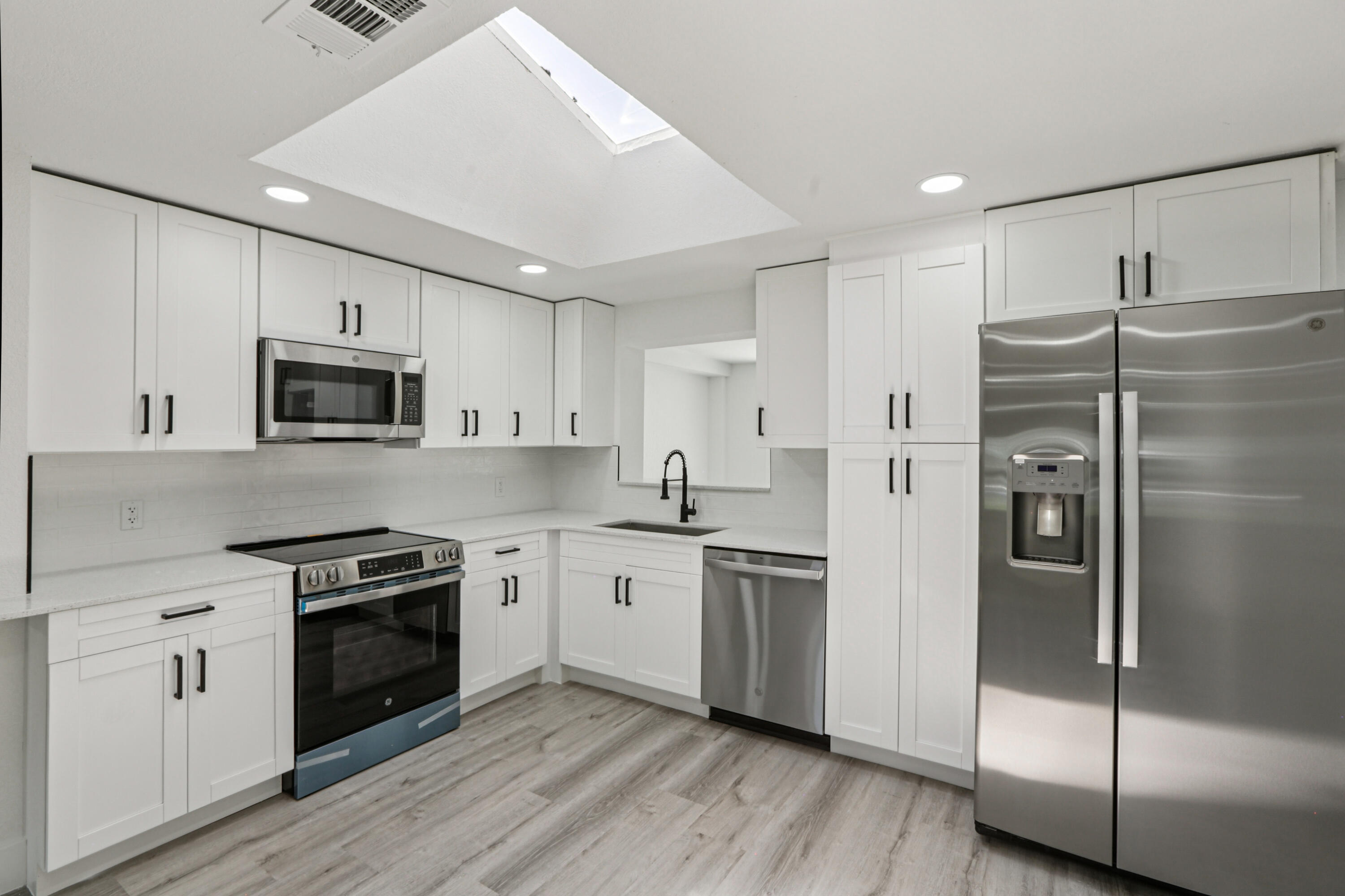 4946 Avery Road New Port Richey, FL 34652 - Photo 2 of 10 a kitchen with cabinets stainless steel appliances and wooden floor