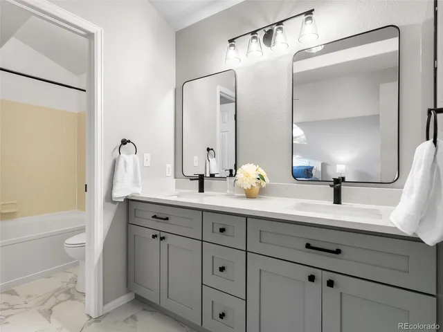 a bathroom with a double vanity sink mirror double and bathtub