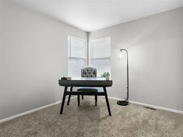 a workspace room with furniture and a window