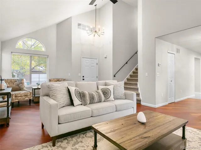 a living room with furniture and a wooden floor