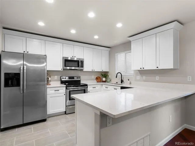 a kitchen with a sink stainless steel appliances and white cabinets