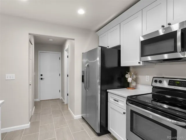 a kitchen with stainless steel appliances white cabinets and a stove top oven