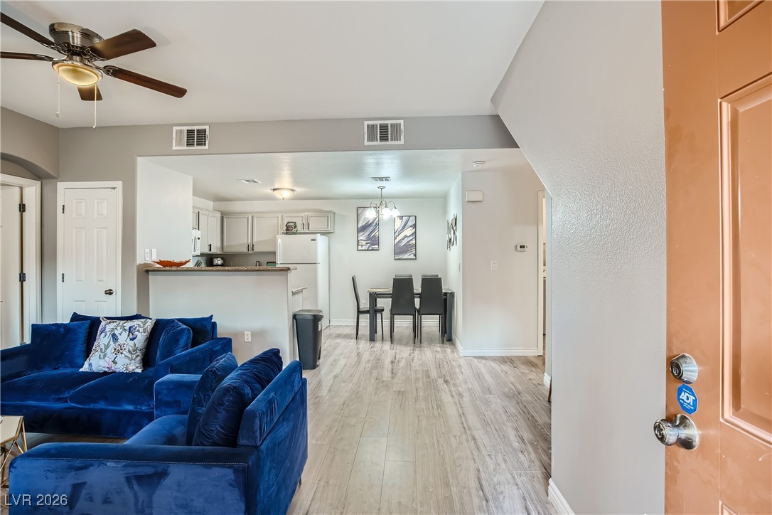 7701 West Robindale Road, Unit 149 Las Vegas, NV 89113 - Photo 3 of 22 Living area featuring light wood finished floors and a ceiling fan