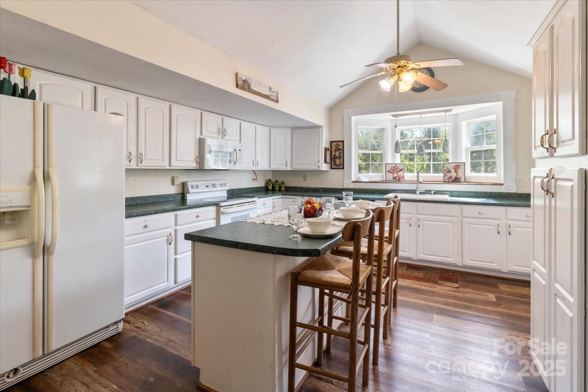 201 Murphy Hill Road Weaverville, NC 28787 - Photo 19 of 48 a kitchen with stainless steel appliances granite countertop a table chairs sink refrigerator and microwave