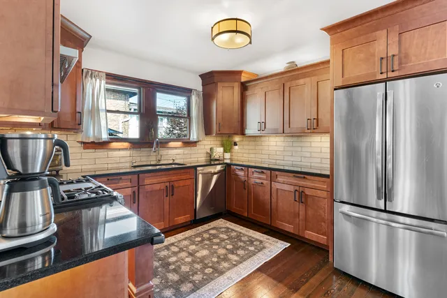 a kitchen with stainless steel appliances granite countertop a refrigerator stove and sink