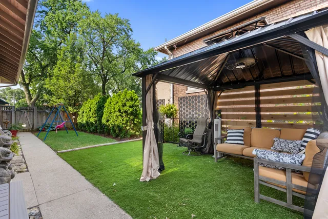 a view of a patio with table and chairs under an umbrella