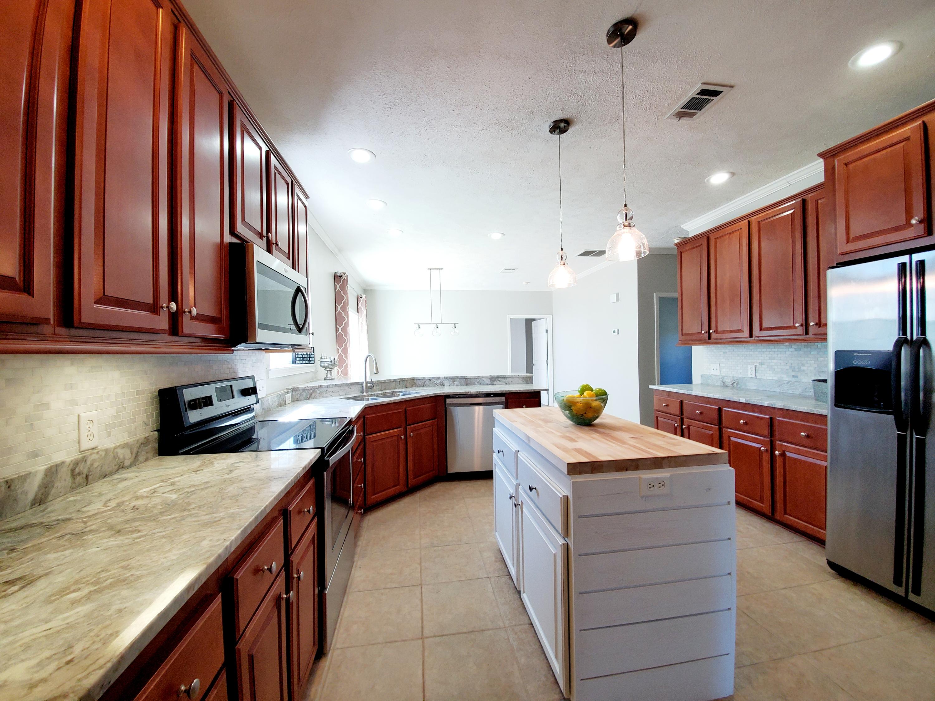 456 East Nursery Road Santa Rosa Beach, FL 32459 - Photo 3 of 21 a kitchen with stainless steel appliances granite countertop a sink stove and refrigerator