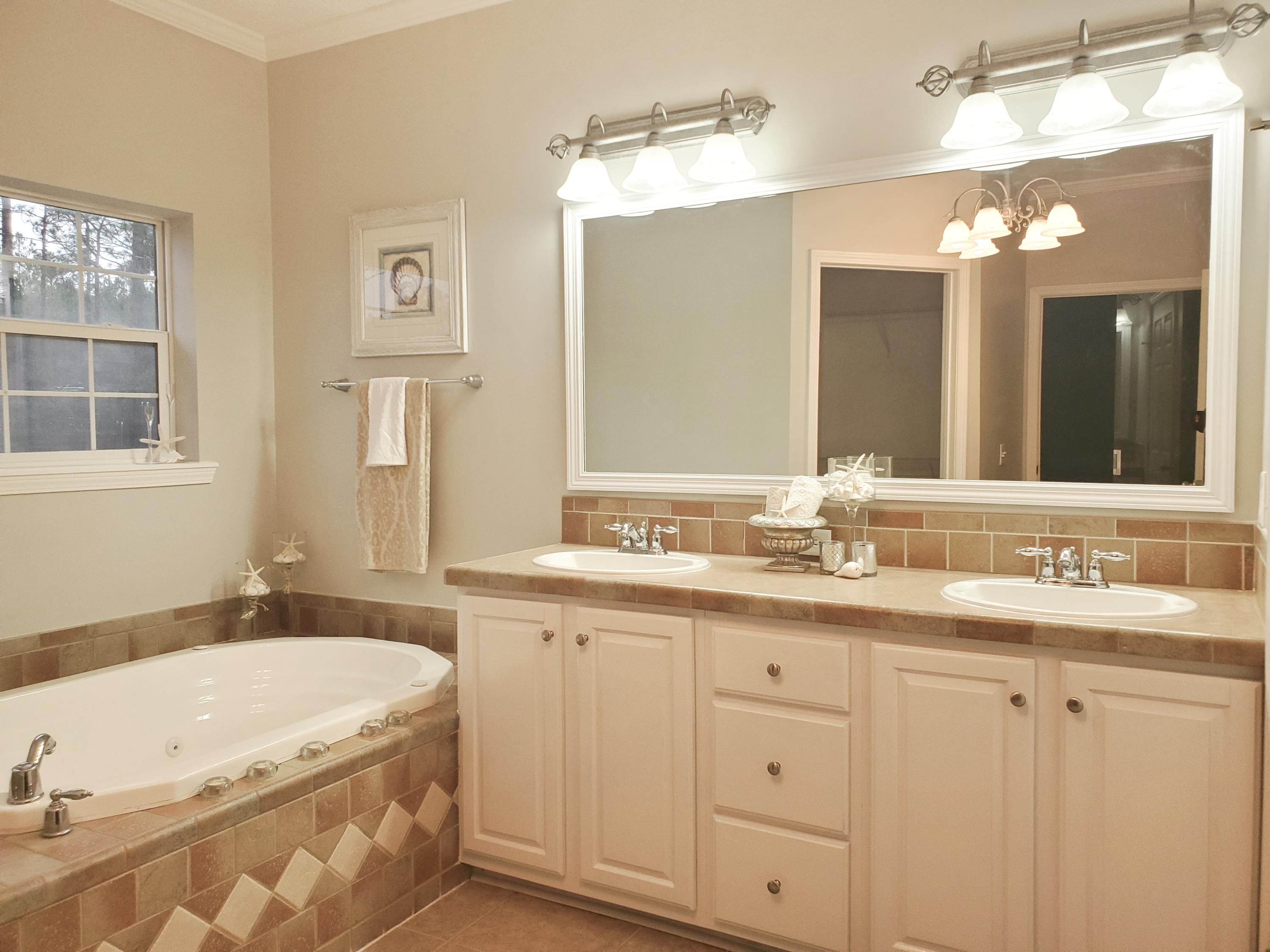 456 East Nursery Road Santa Rosa Beach, FL 32459 - Photo 9 of 21 a bathroom with a granite countertop sink mirror and a bathtub
