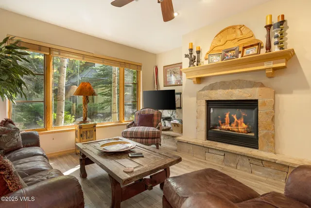 a living room with furniture a fireplace and a large window with balcony view