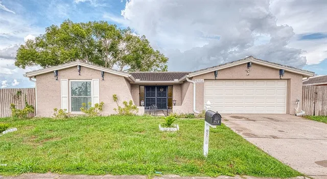 a view of a yard in front of a house with large windows