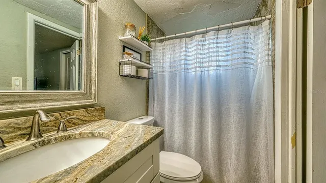 a bathroom with a granite countertop sink and a mirror
