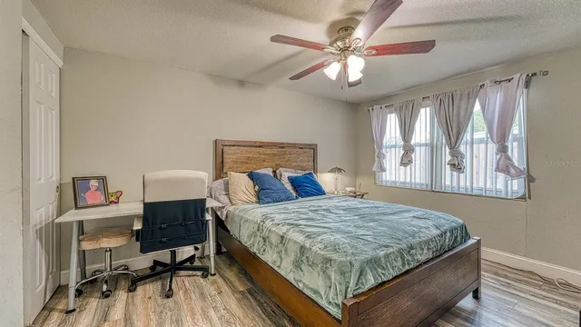 a bedroom with a large bed a chandelier and a window