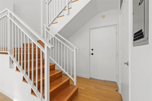 a view of staircase with railing and white walls