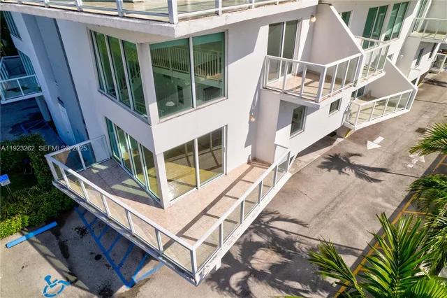 a balcony with a potted plant and outdoor seating
