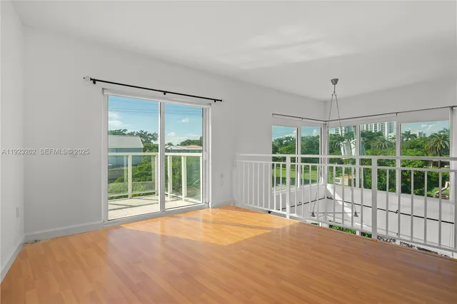 a view of a room with wooden floor and a large window