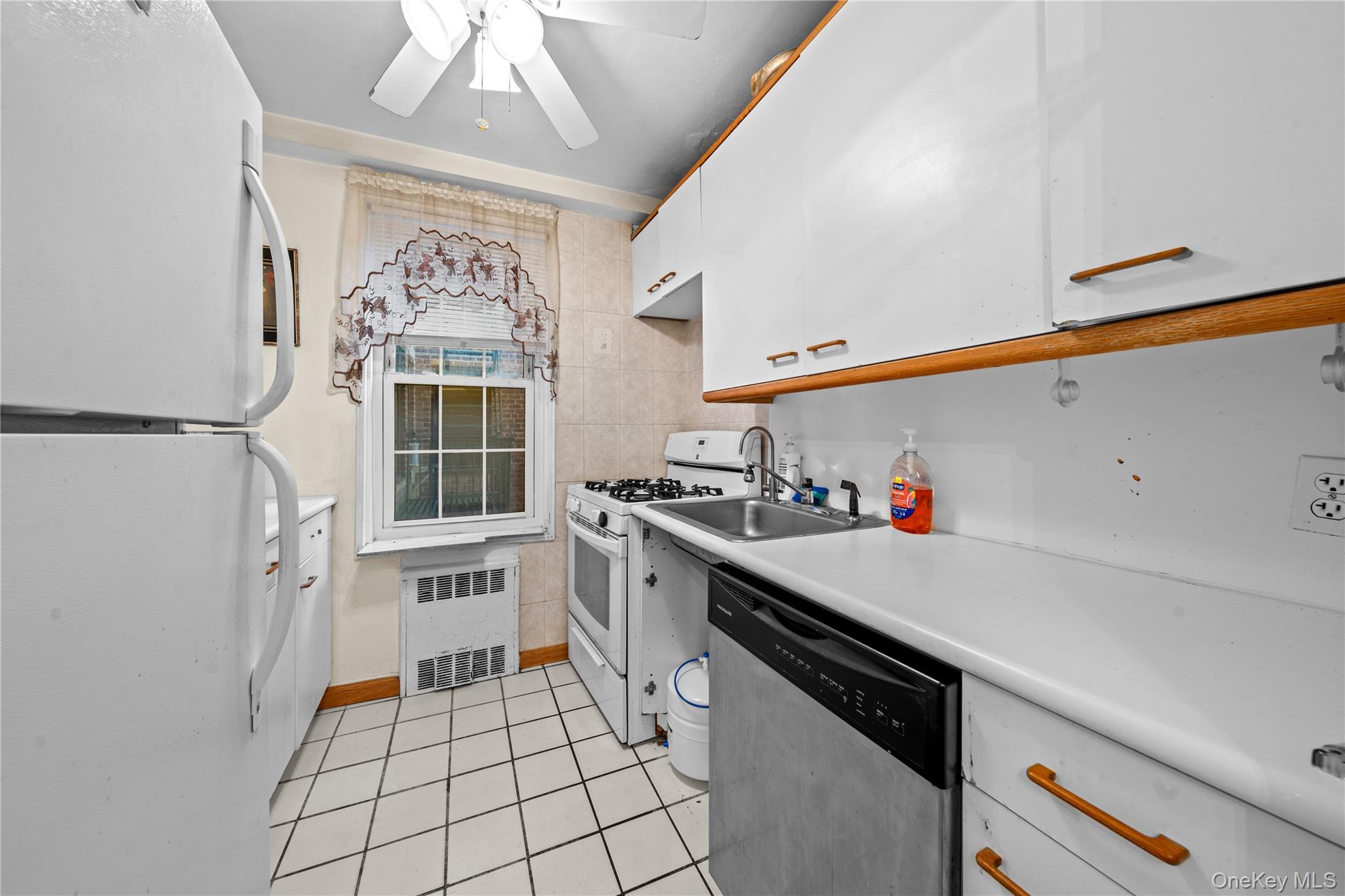 140-18 Burden Crescent, Unit 305 Queens, NY 11435 - Photo 9 of 15 a kitchen with a sink a stove and cabinets