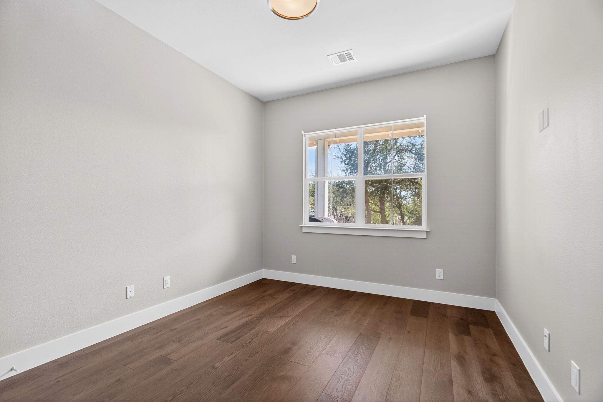 7803 Ryans Way Austin, TX 78726 - Photo 13 of 38 The main-floor secondary bedroom offers flexibility for guests or a home office.