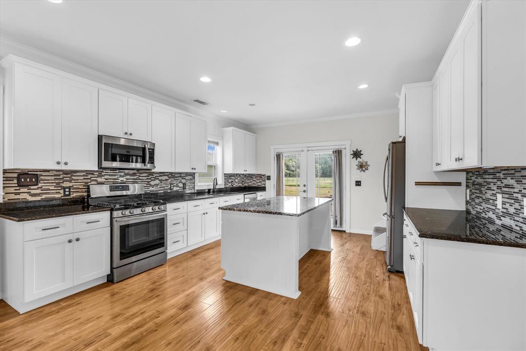 348 Barker Lane Waco, TX 76705 - Photo 11 of 39 a large kitchen with cabinets wooden floor and stainless steel appliances