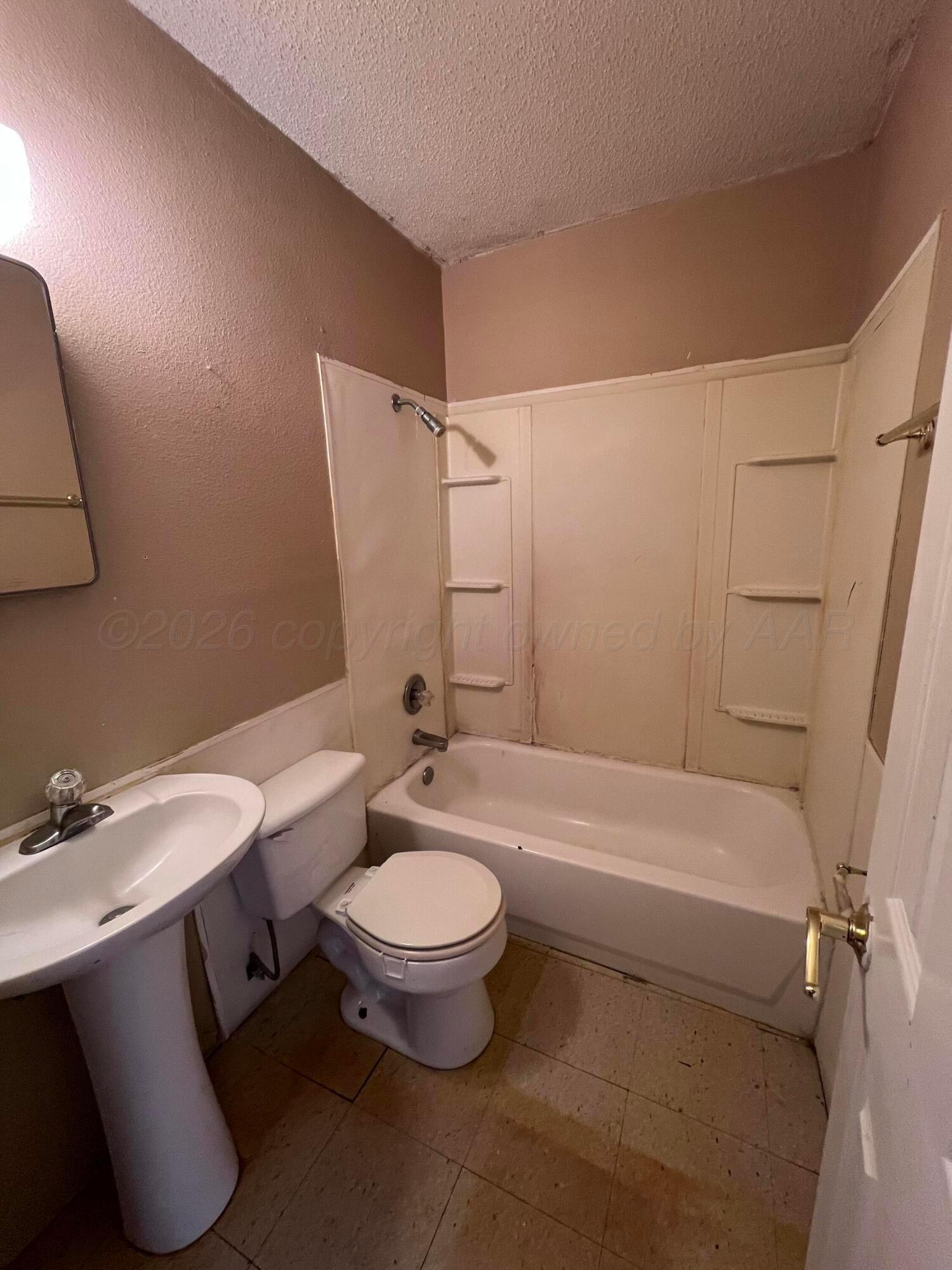 828 Blevins Street Hereford, TX 79045 - Photo 14 of 14 a bathroom with a sink a toilet and bathtub