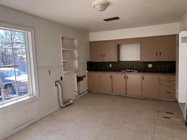 a kitchen with granite countertop white cabinets and window