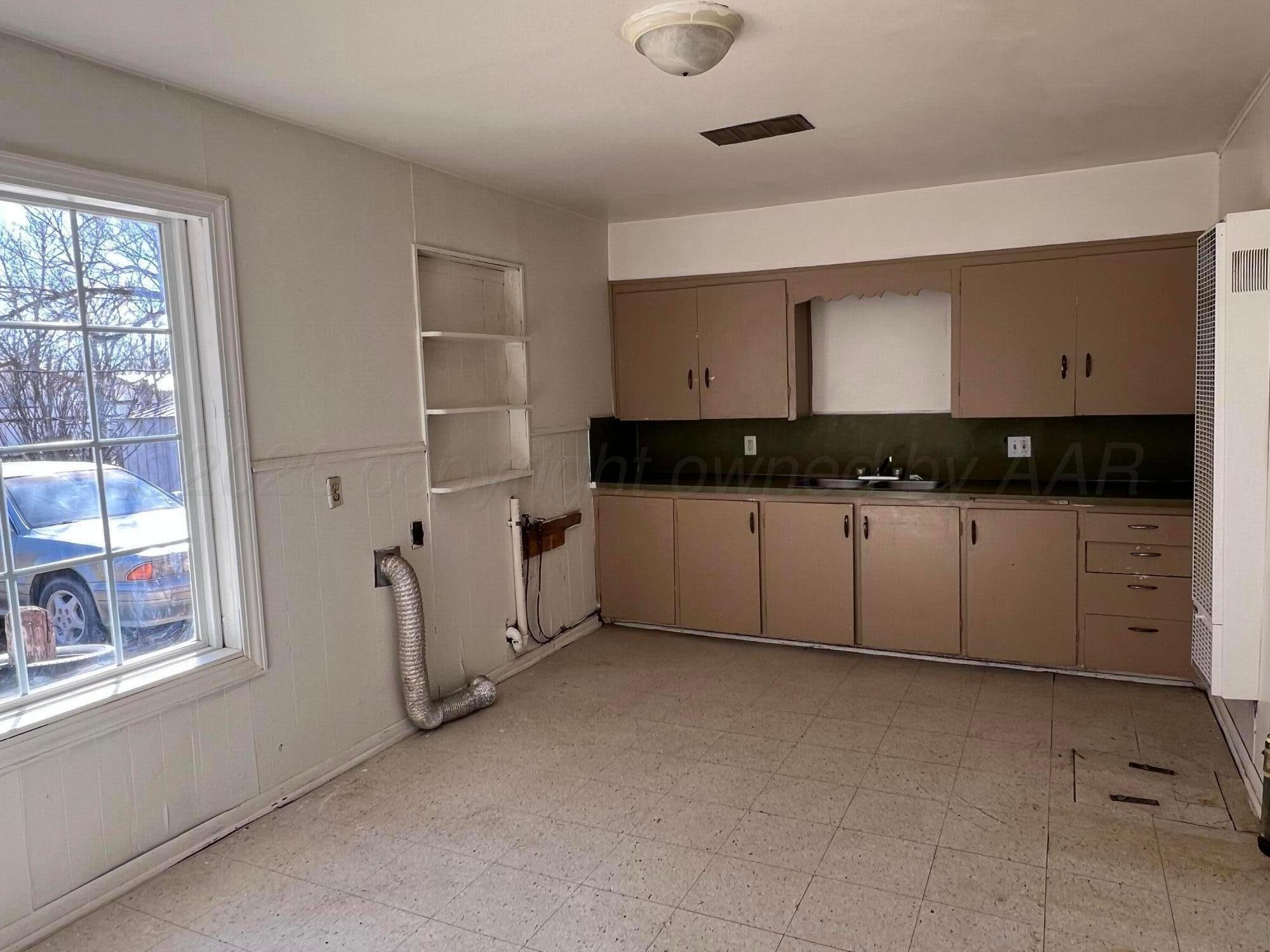 828 Blevins Street Hereford, TX 79045 - Photo 7 of 14 a kitchen with granite countertop white cabinets and window
