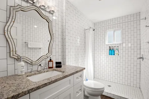 a bathroom with a granite countertop sink and a mirror
