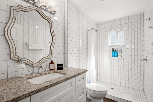 1183 Coleto Street Austin, TX 78702 - Photo 16 of 17 a bathroom with a granite countertop sink and a mirror