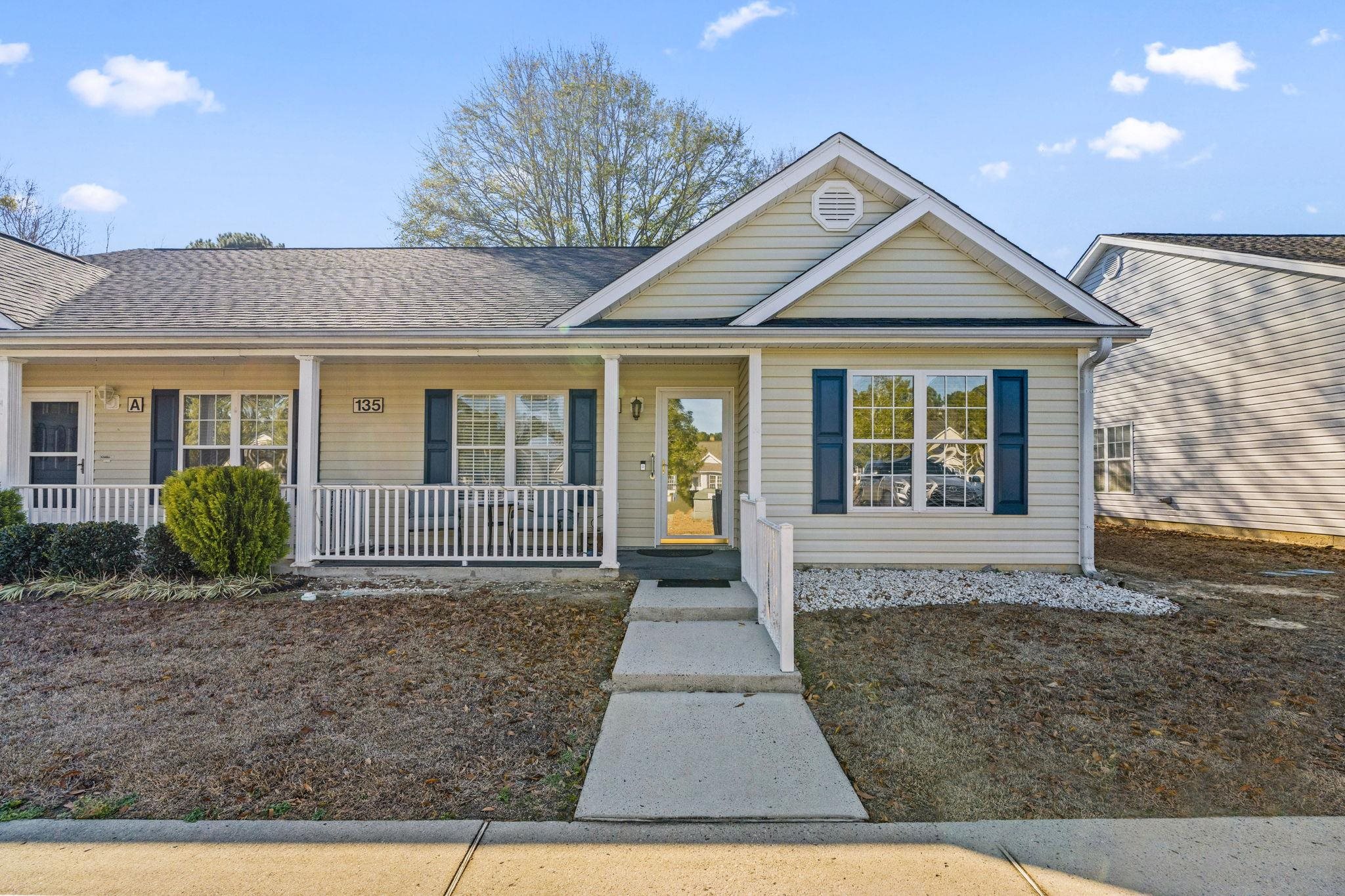 View of front of home featuring covered porch and a shingled roof