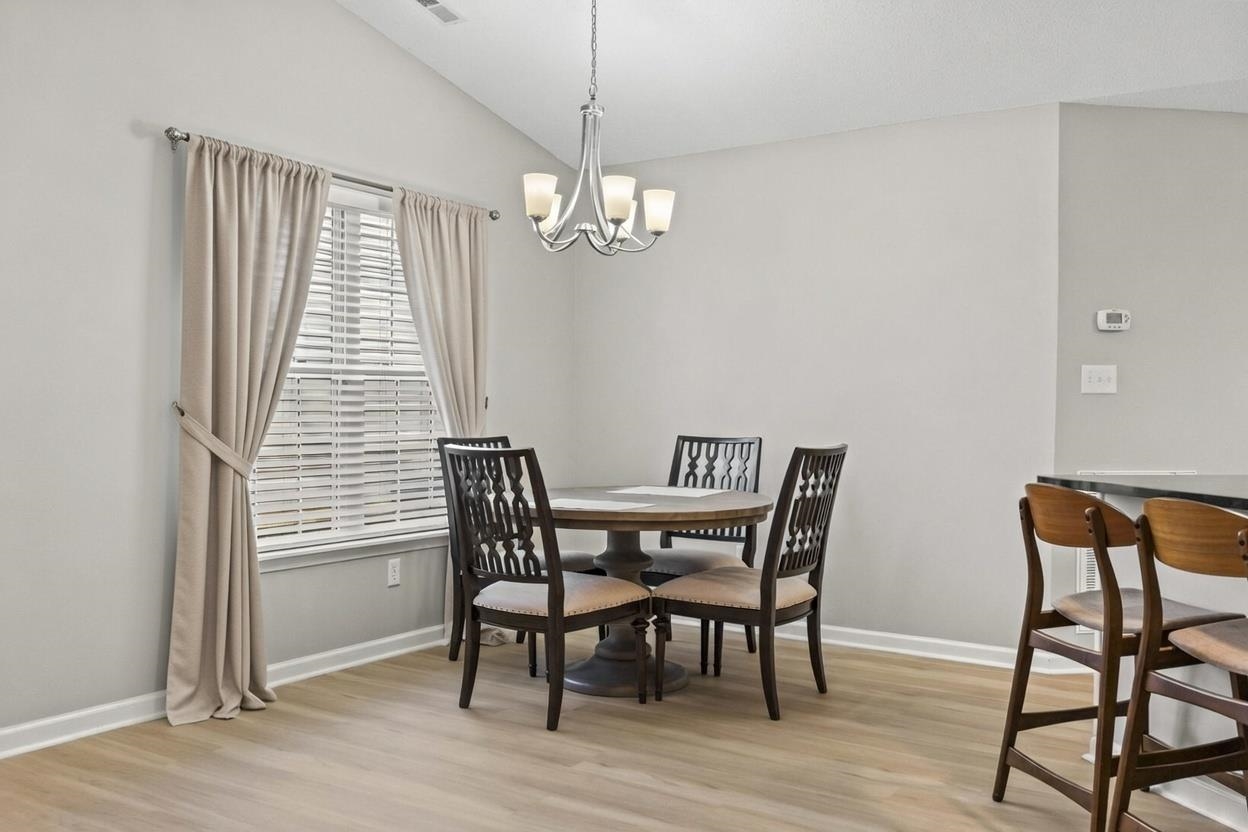 135 Country Manor Drive, Unit B Conway, SC 29526 - Photo 13 of 40 Dining area with light wood-style floors, lofted ceiling, and a chandelier