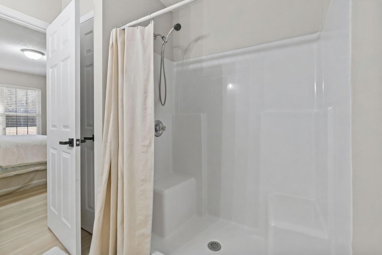 135 Country Manor Drive, Unit B Conway, SC 29526 - Photo 20 of 40 Full bathroom featuring ensuite bathroom, a shower stall, a textured ceiling, and wood finished floors