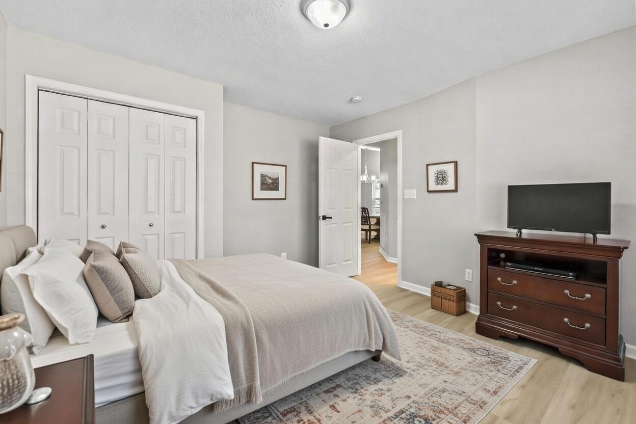 135 Country Manor Drive, Unit B Conway, SC 29526 - Photo 24 of 40 Bedroom with a closet, light wood finished floors, a textured ceiling, and a chandelier