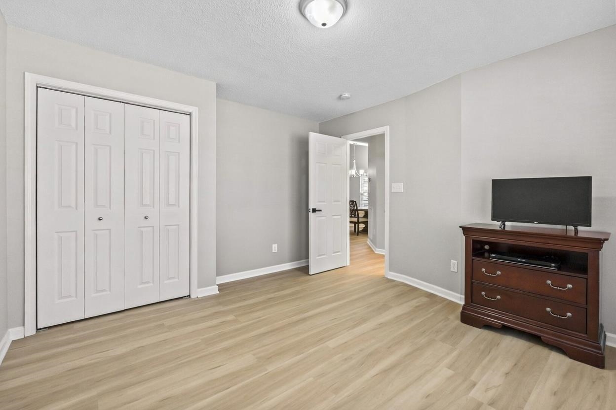 135 Country Manor Drive, Unit B Conway, SC 29526 - Photo 25 of 40 Unfurnished bedroom with a textured ceiling, light wood-type flooring, a closet, and a chandelier