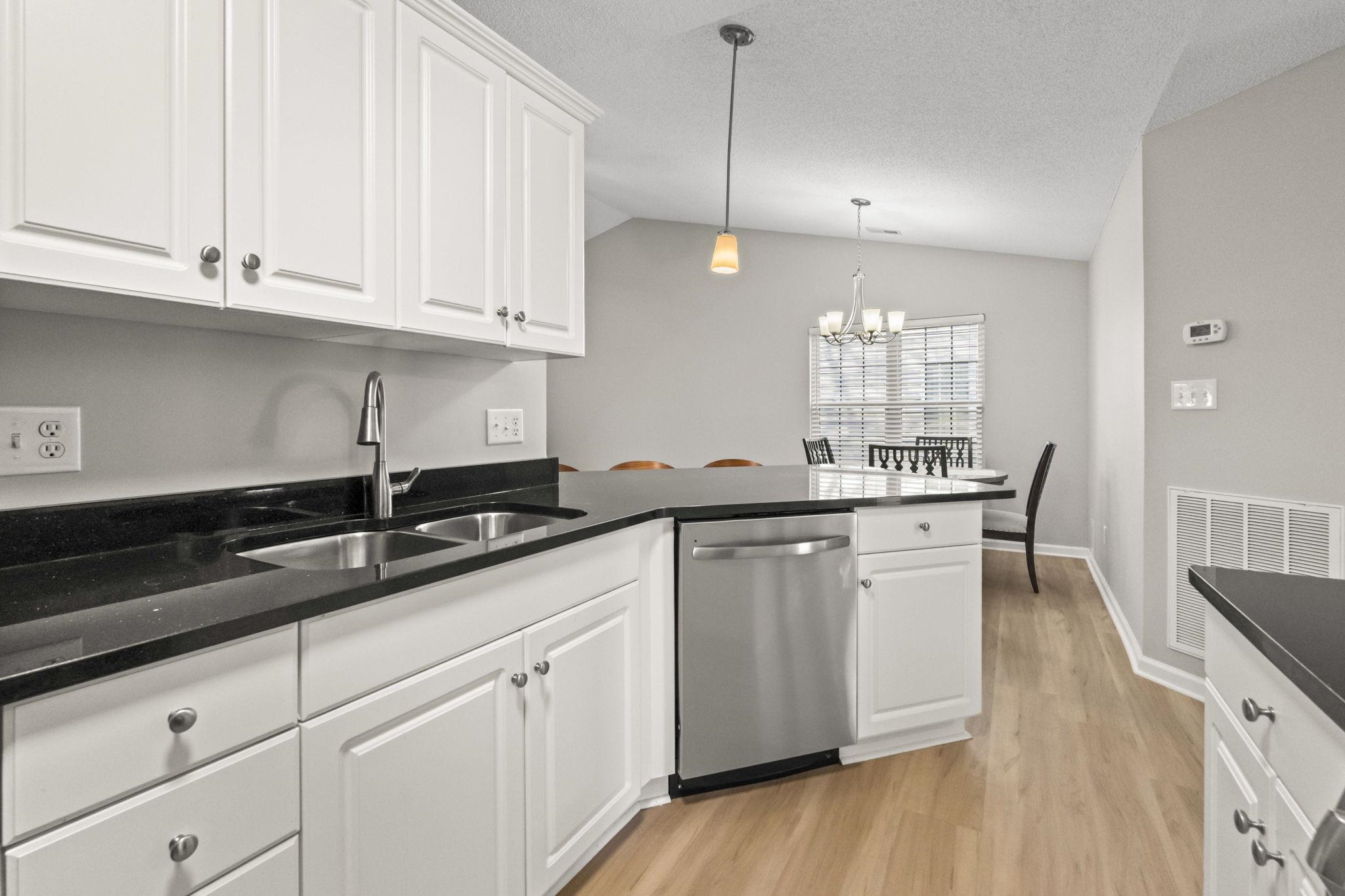 135 Country Manor Drive, Unit B Conway, SC 29526 - Photo 7 of 40 Kitchen with white cabinets, stainless steel dishwasher, pendant lighting, light wood-style flooring, and a chandelier