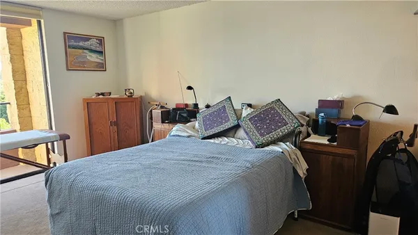 a bedroom with a bed and a dresser with mirror