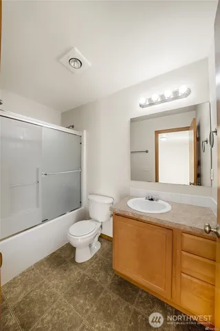 a bathroom with a granite countertop sink toilet a large mirror and shower