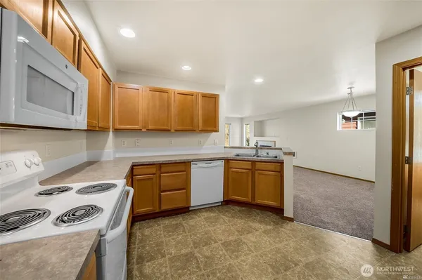 a kitchen with granite countertop a sink stove and cabinets