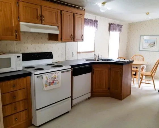 a kitchen with granite countertop a sink stove and cabinets