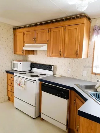 a kitchen with granite countertop a sink stove and cabinets