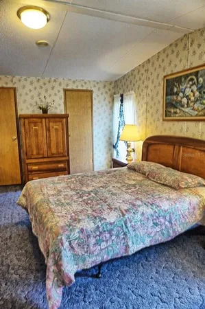 a bedroom with a bed and dresser with mirror
