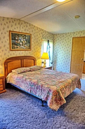 a bedroom with a bed and painting on the wall