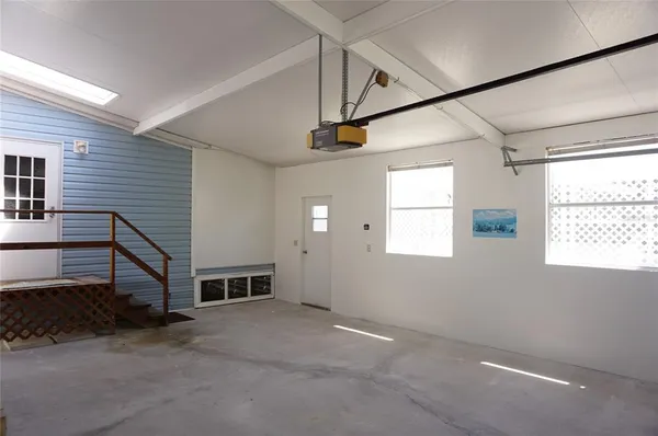 a view of a livingroom with an empty space & a window