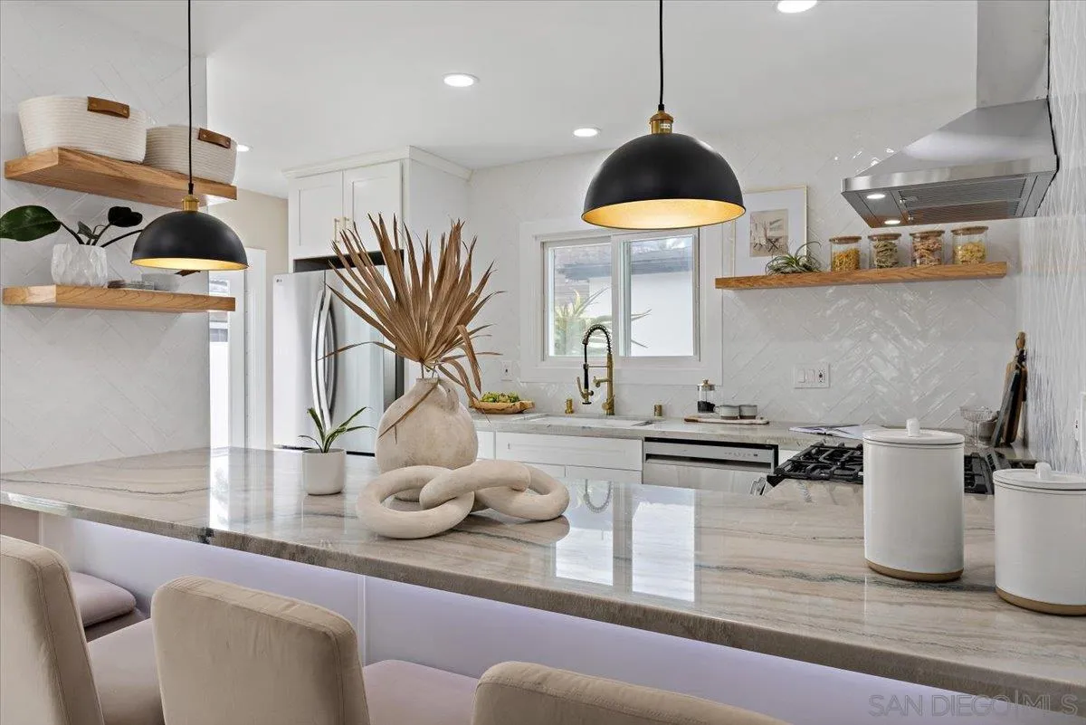 3663 Oleander Drive San Diego, CA 92106 - Photo 12 of 46 a kitchen with stainless steel appliances granite countertop a sink a stove and a wooden floors